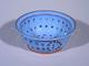 Thrown on the wheel and then made into a colander by poking many, many holes into the form...